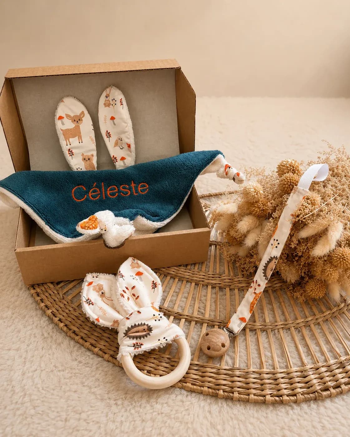 Accessoires de naissance assortis avec doudou plat doux et attache-tétine aux tons automnaux.
