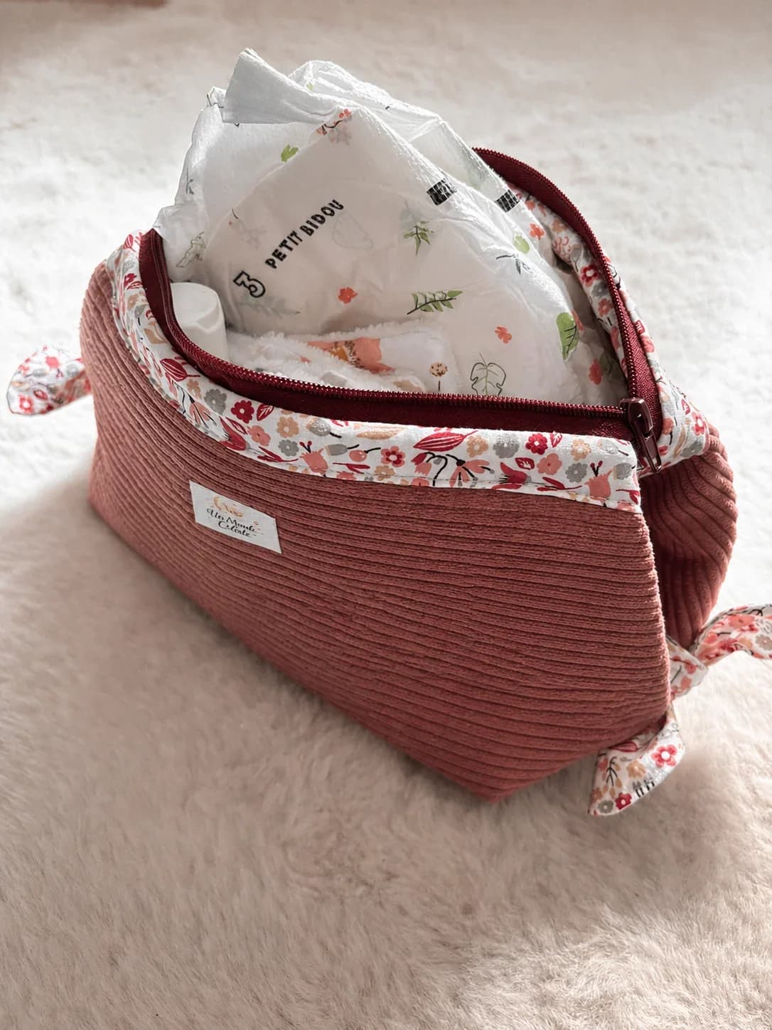 Trousse de toilette Pétales d'amour en velours côtelé rose avec doublure fleurie.