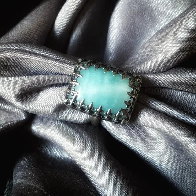 Vue de dessus de la bague Brume sertie d'une calcite bleue sur satin gris